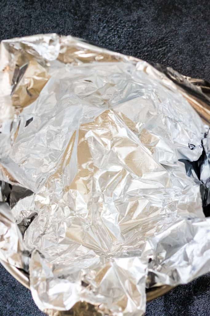 A table with a bowl of aluminum foil.