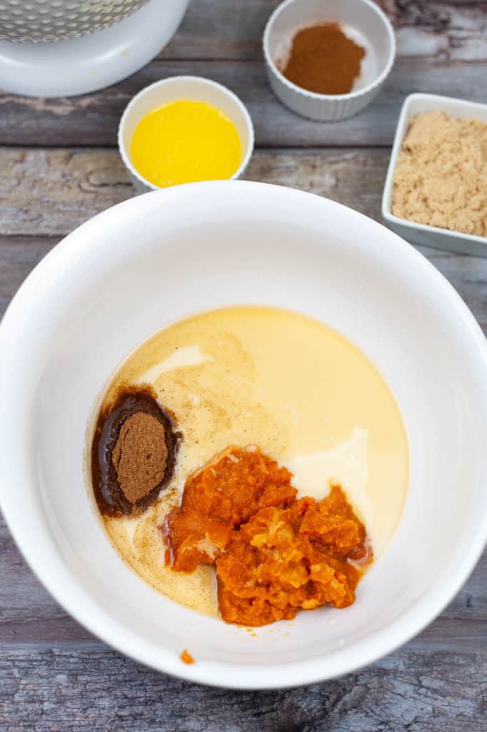 A white bowl with ingredients for a pumpkin ice cream.