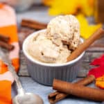 Low angle shot of a ramekin filled with pumpkin ice cream with a cinnamon stick in it