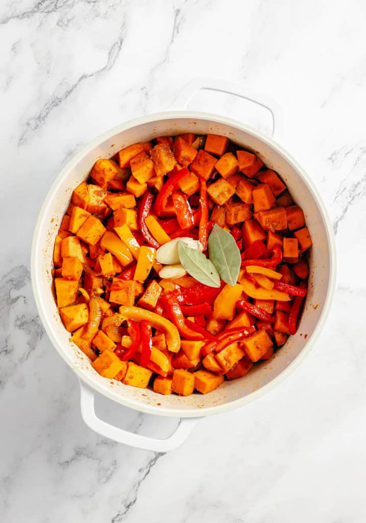 Roasted sweet potatoes in a white pan on a marble countertop, served with Thai pumpkin curry.