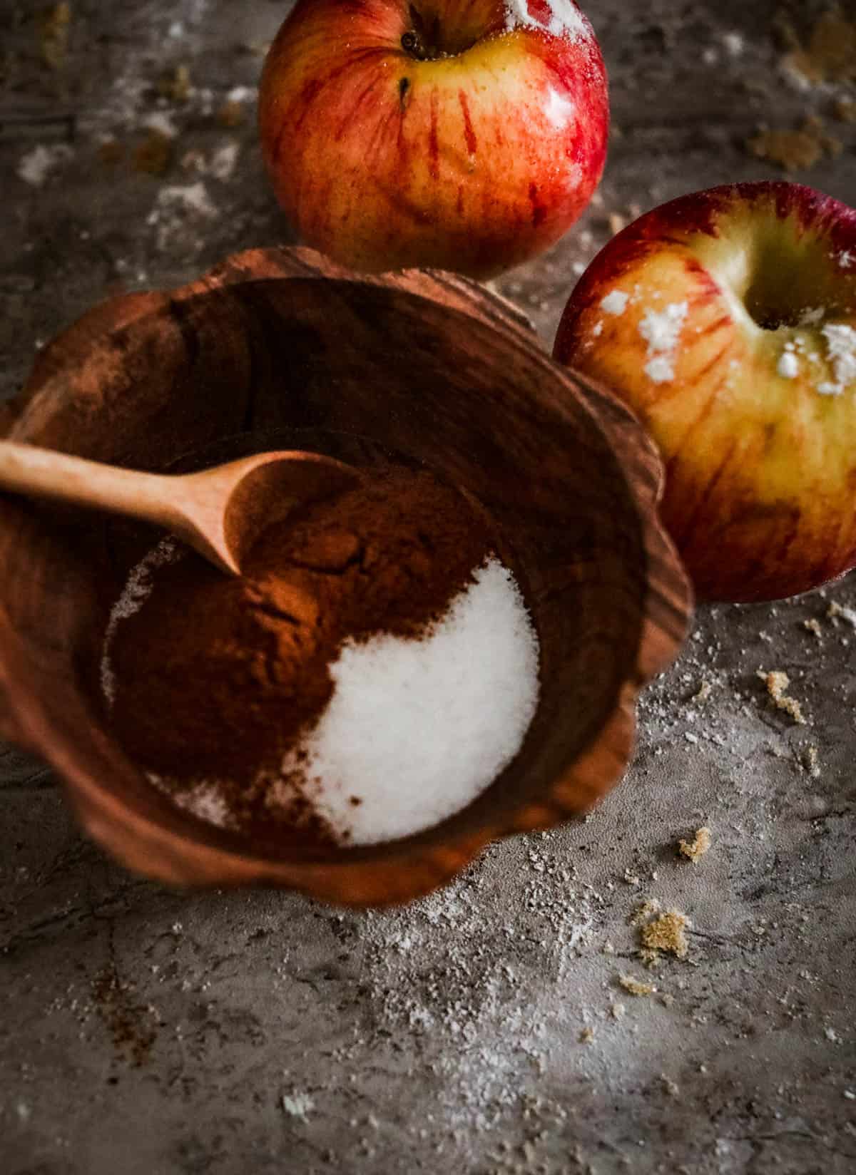 Apples and sugar are used to make a delicious apple cider donut cake served in a wooden bowl.