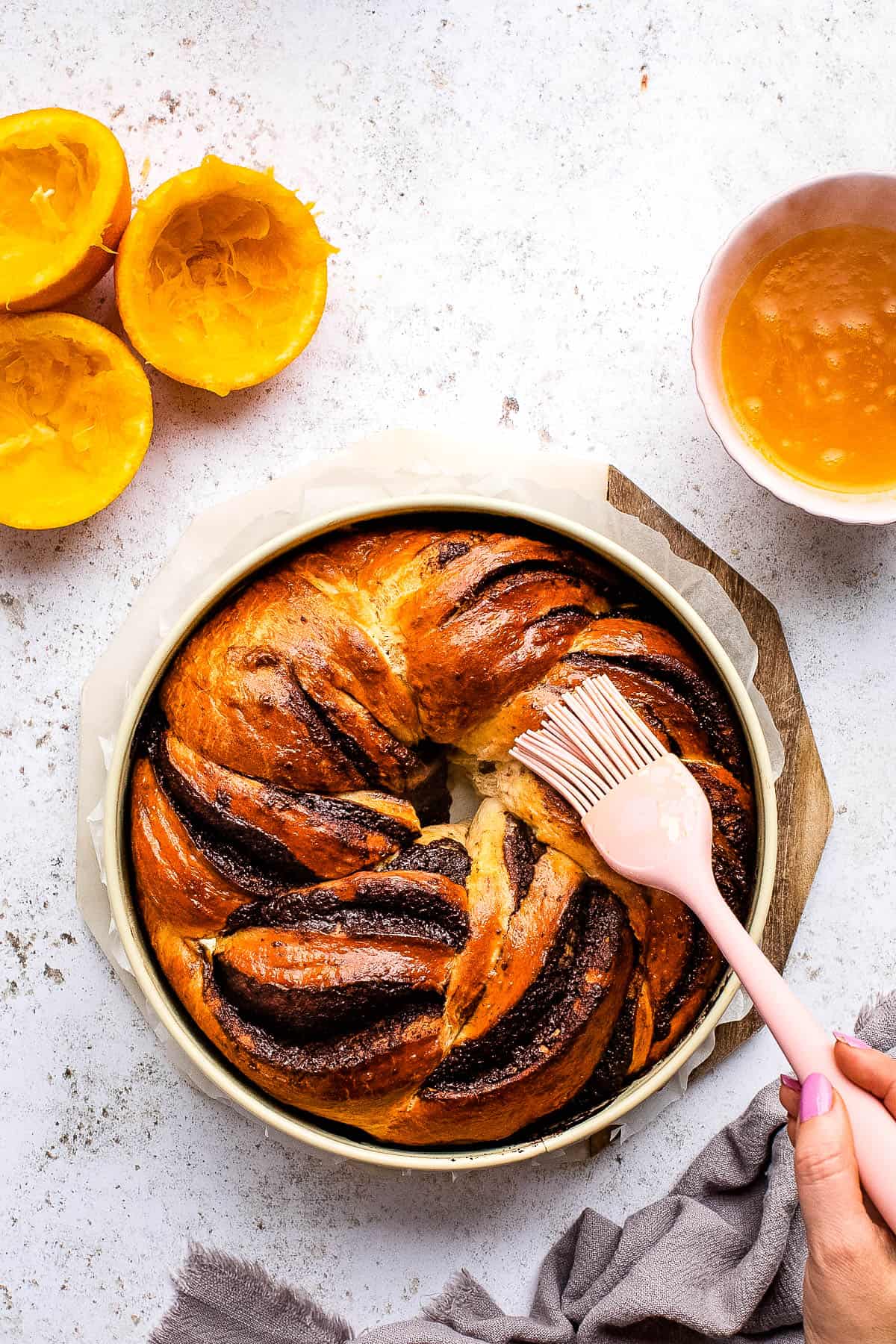 A person is preparing a chocolate babka in a pan.