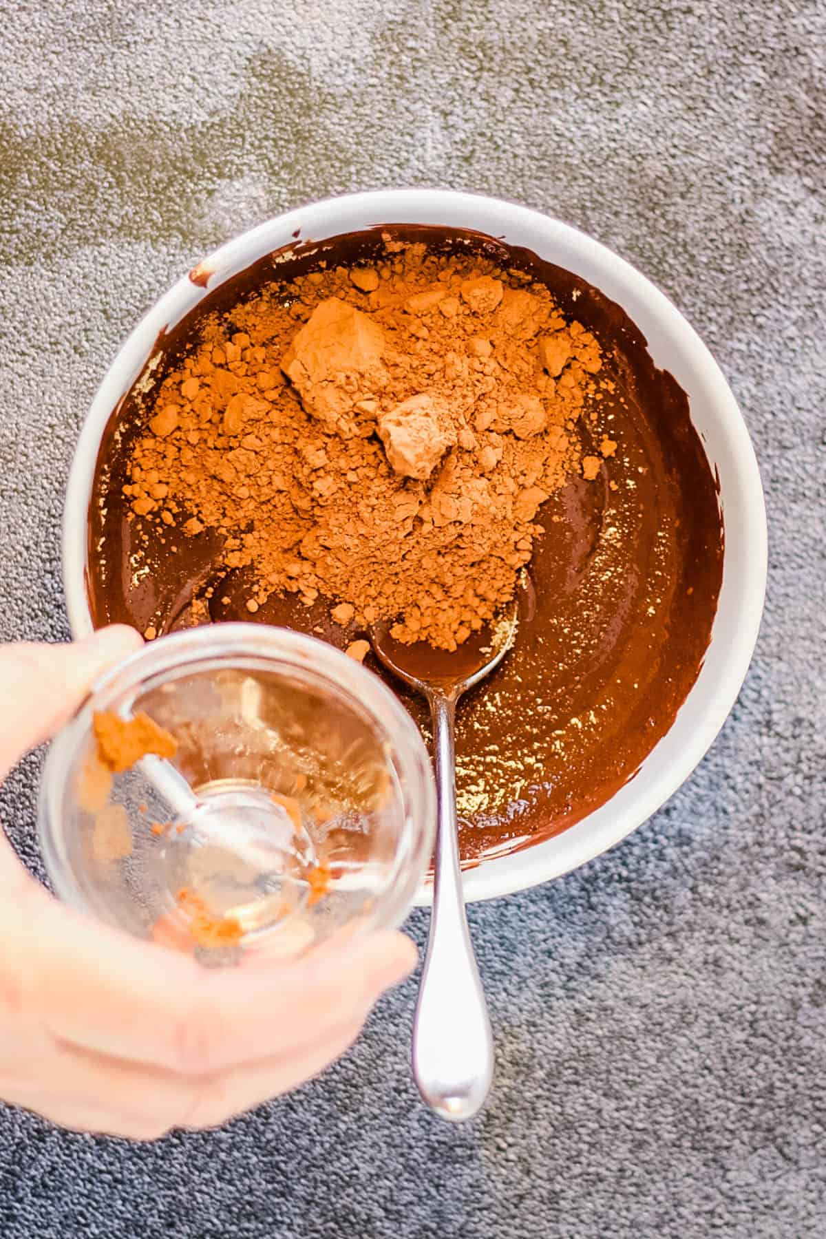 Adding cocoa powder to the chocolate.