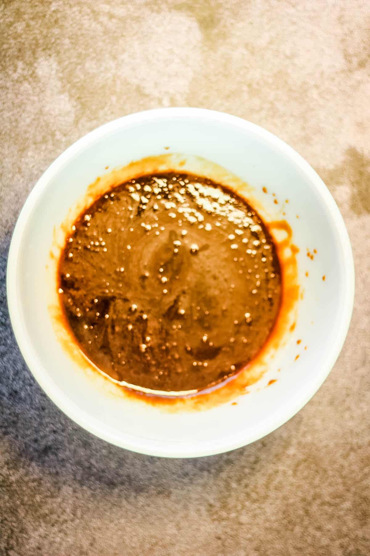 A bowl of ginger snap sauce on a table.