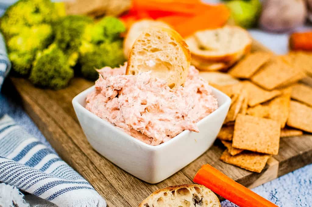 low angle shot of smoked salmon dip with crackers and veggies