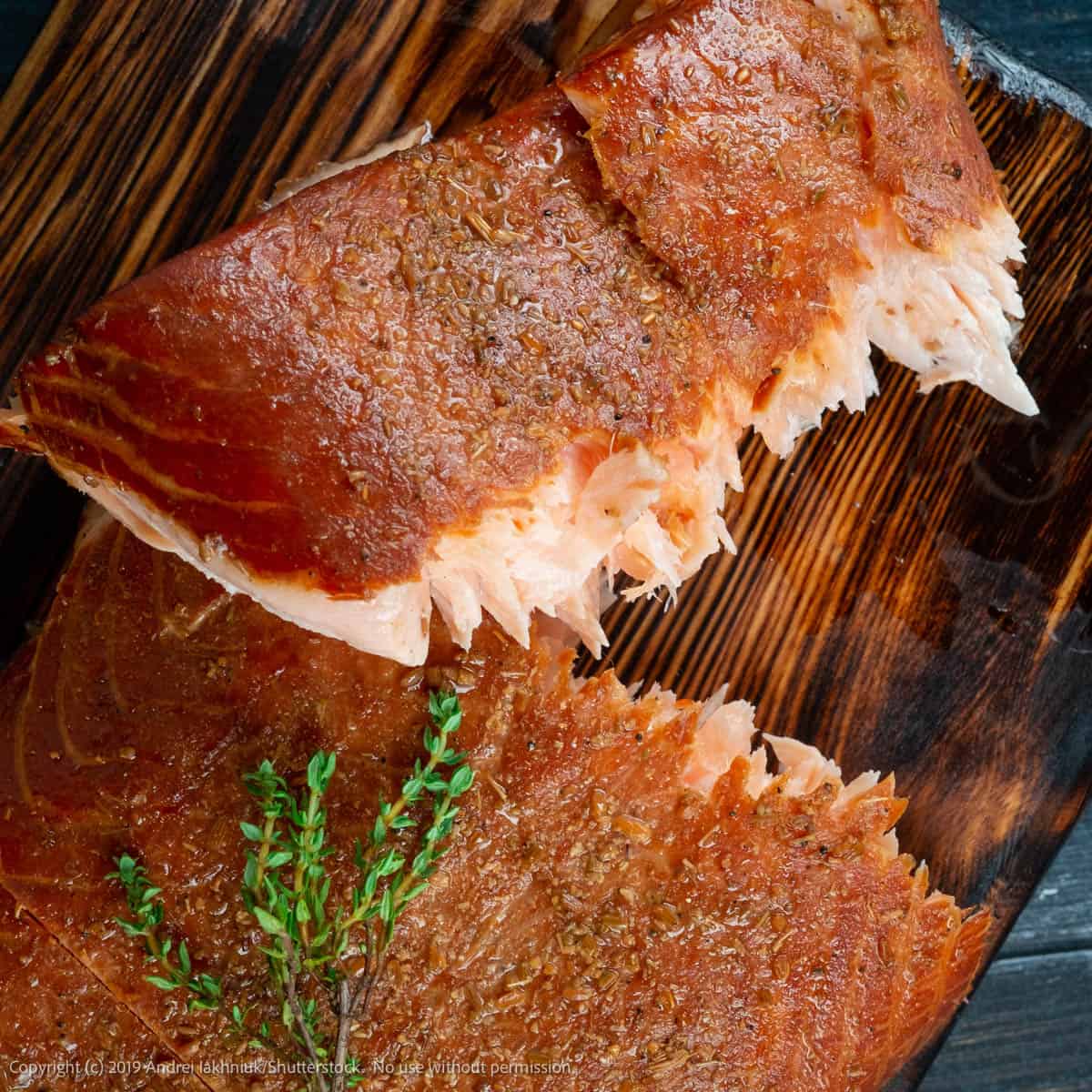 overhead shot of two pieces of smoked salmon garnished with fresh thyme