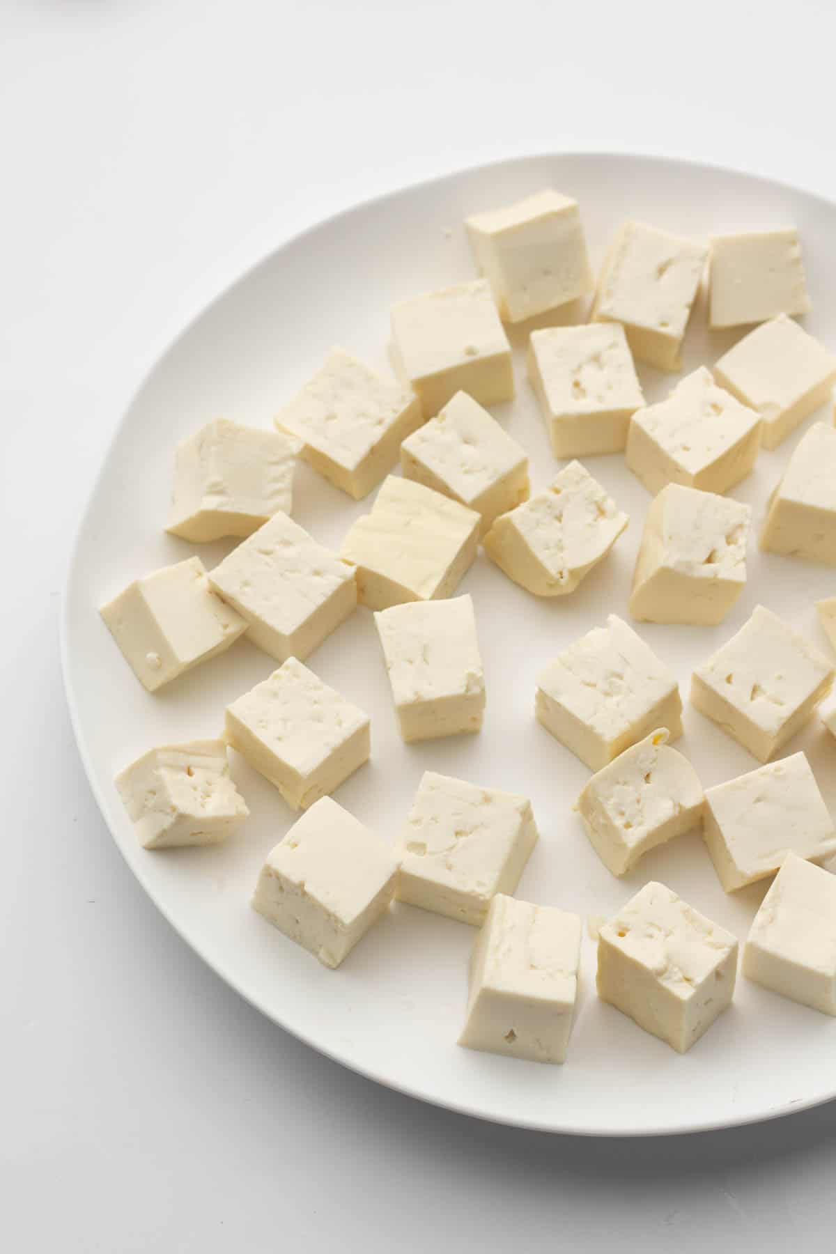 Air-fried tofu cubes on a white plate.