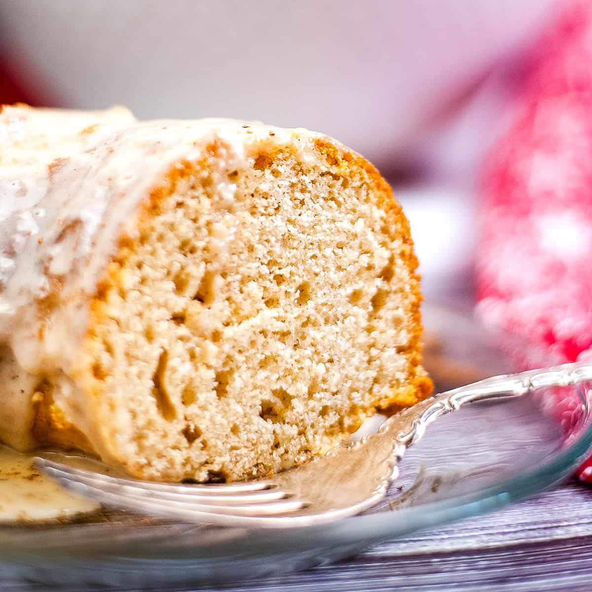 low angle shot of a slice of eggnog cake on a plate with a fork