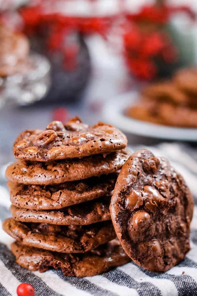 Stack of flourless chocolate cookies on a striped napkin.