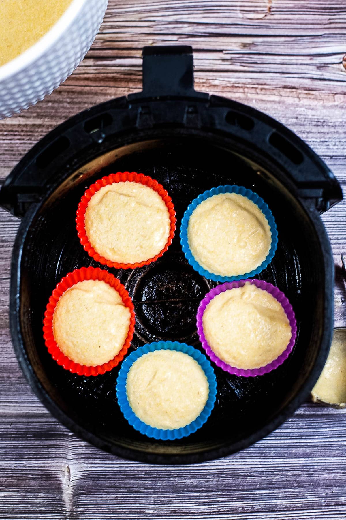 A muffin tin with cornbread cupcakes in it.