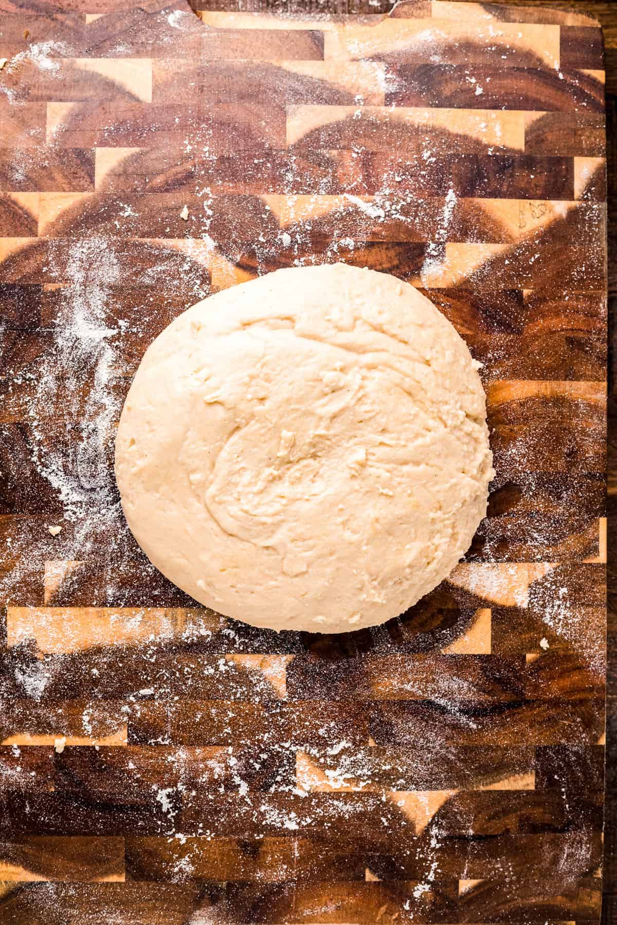 Mochi dough on a wooden cutting board.