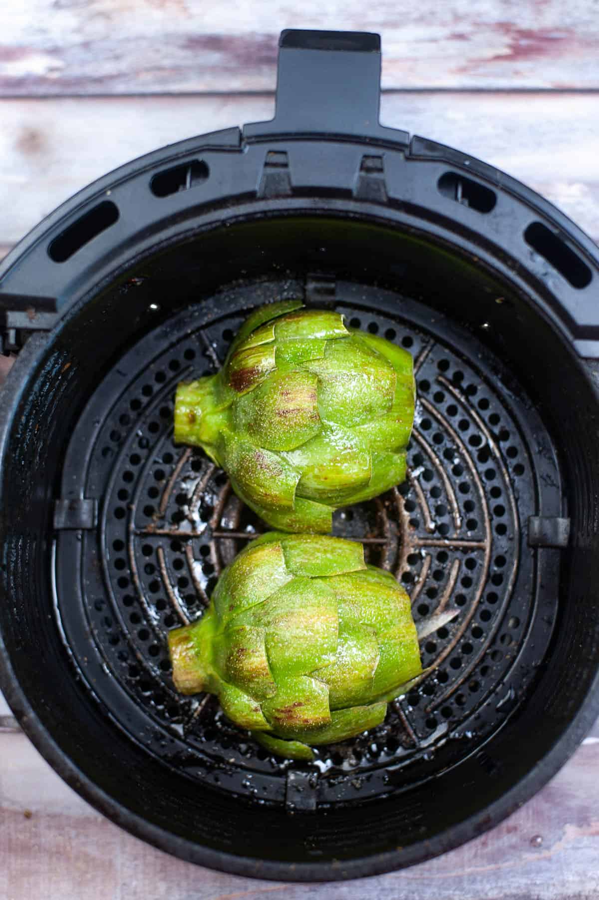 Artichokes cooked perfectly in an air fryer.