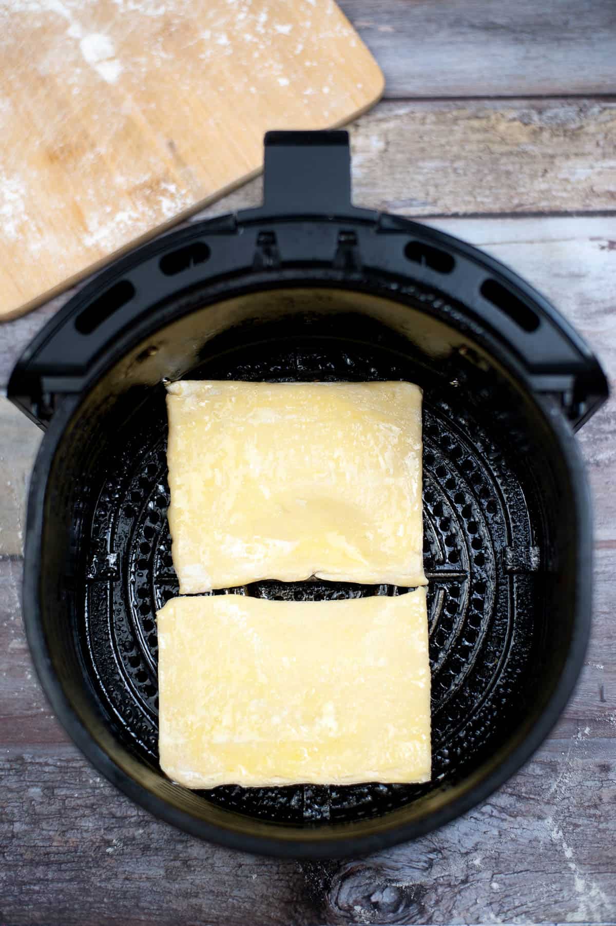 puff pastry squares in air fryer basket.