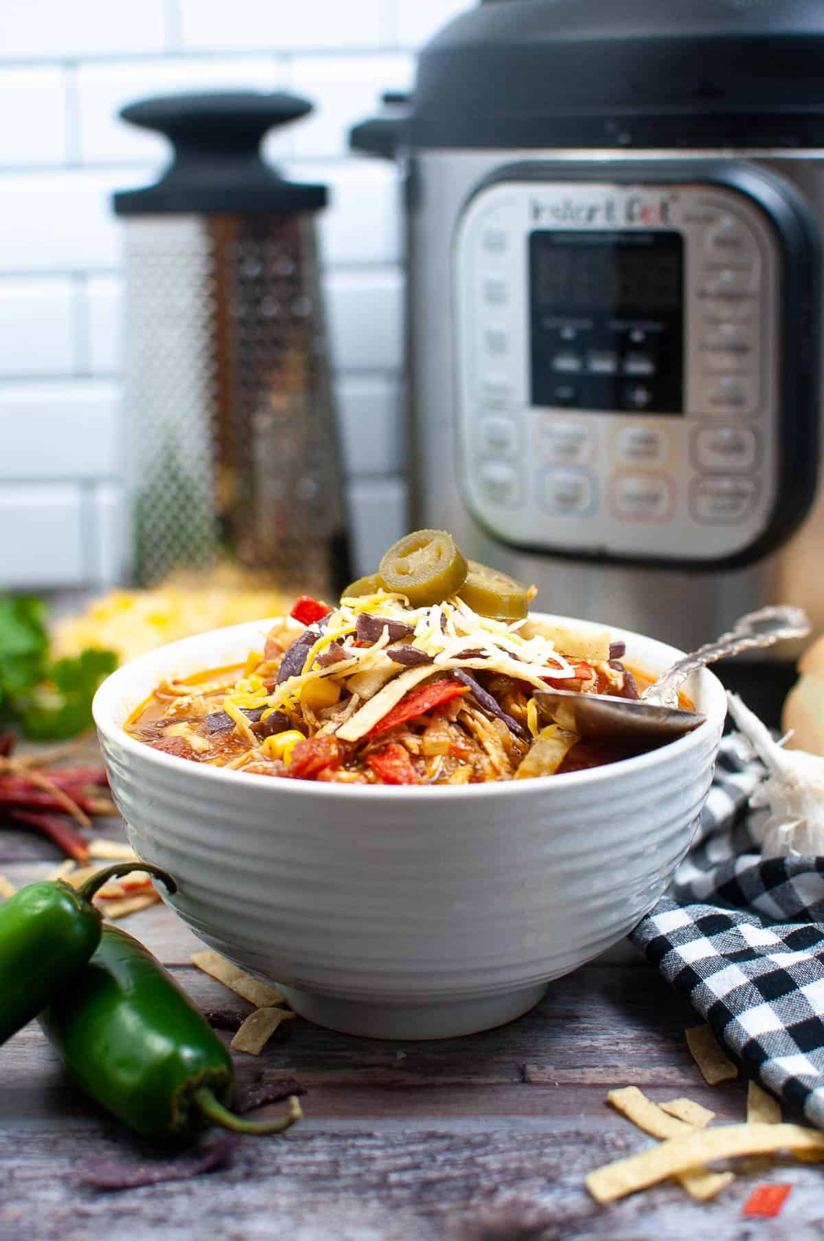 Low angle shot of the tortilla soup with the Instant Pot in the background.