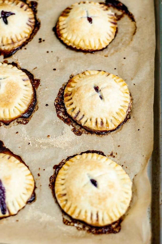 Blueberry hand pies on a baking sheet.