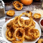 low angle shot of a plate of air fried onion rings.
