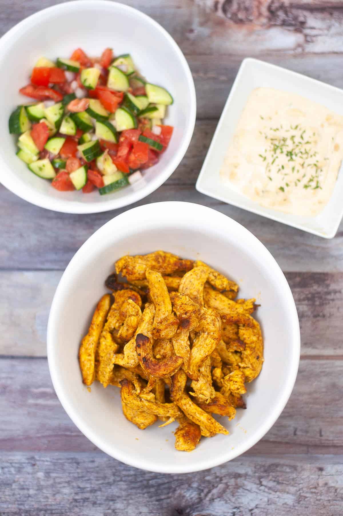Air fryer chicken with vegetables and dip served in two bowls.