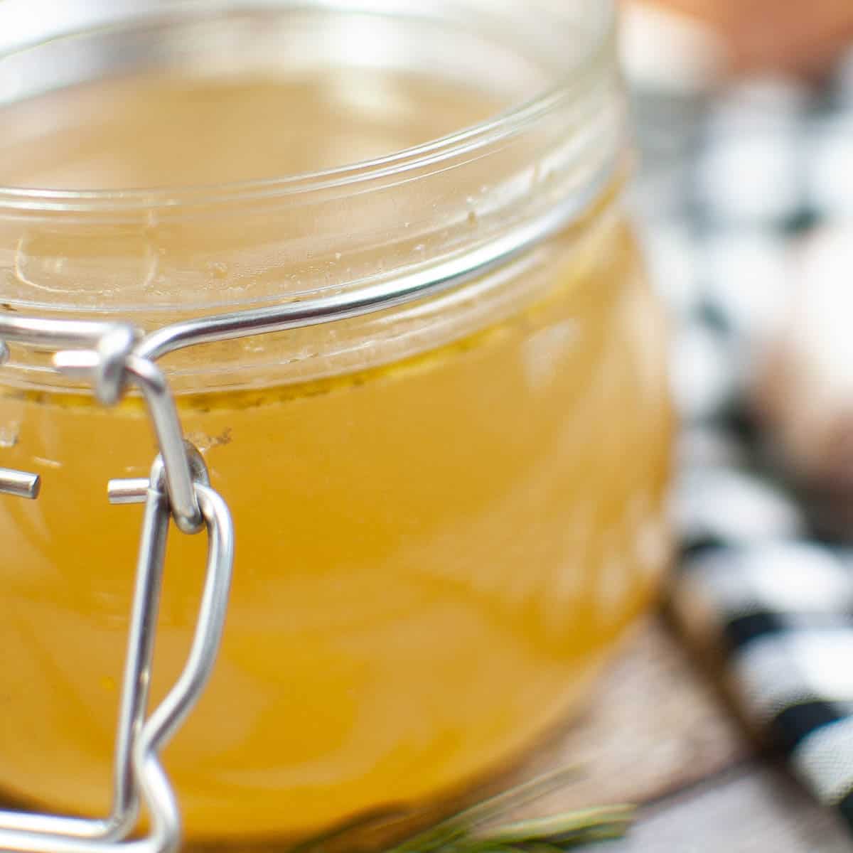Close up shot of a canning jar filled with chicken stock.