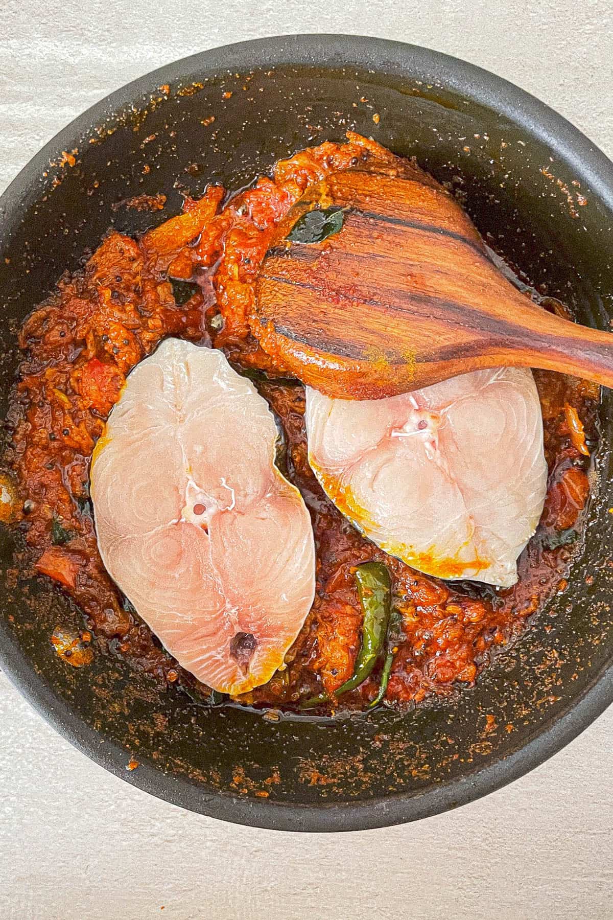 Kerala fish curry cooked in a frying pan.