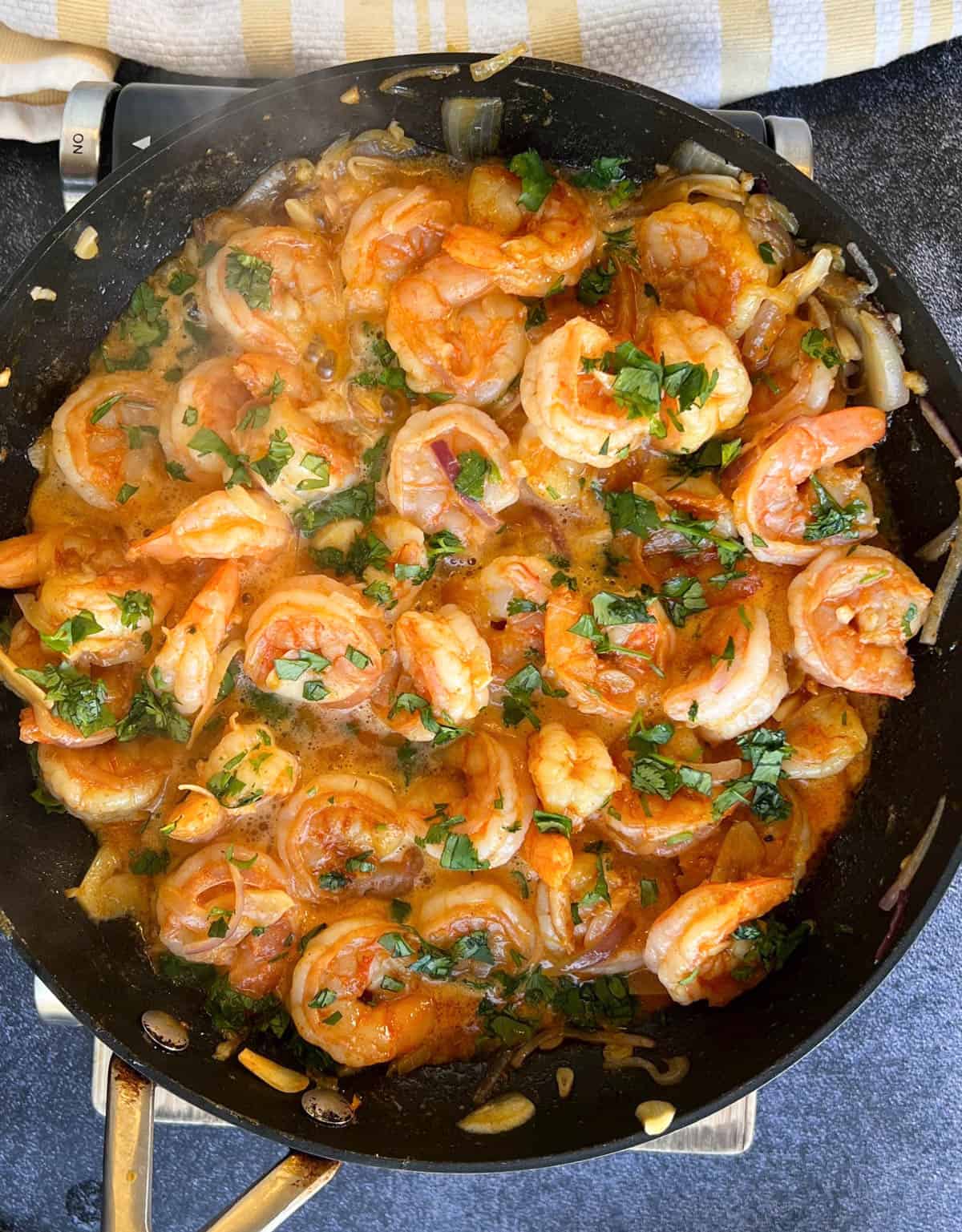 the cooked shrimp in the skillet garnished with cilantro.