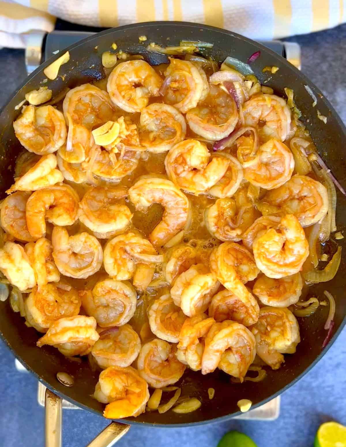 flipping the shrimp over to cook on the other side.