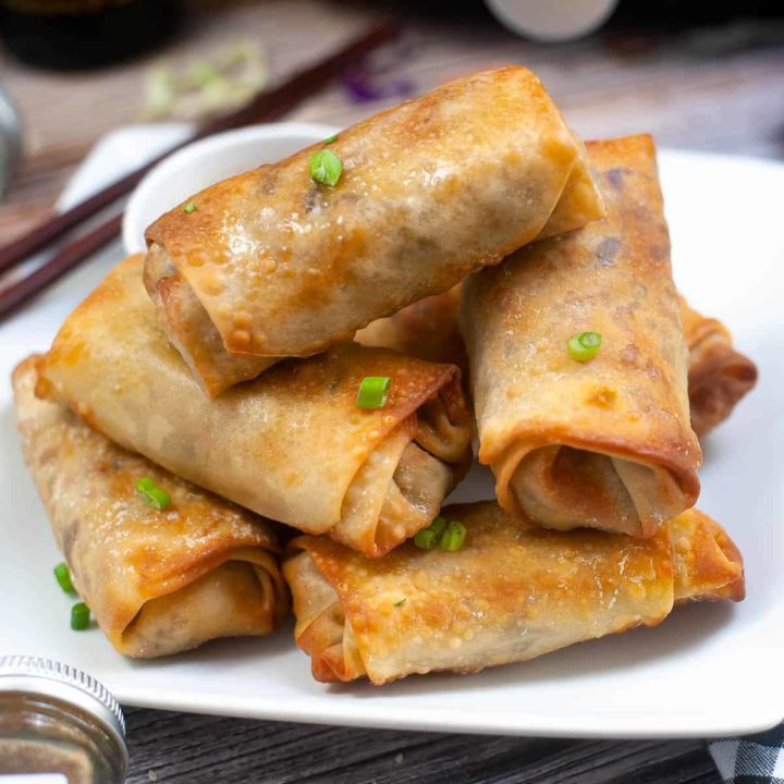 close-up, low angle shot of a pile of air fryer spring rolls on a plate.