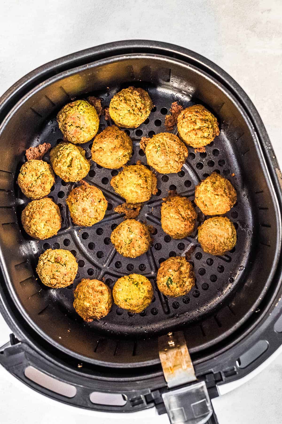 An air fryer filled with fried falafel.