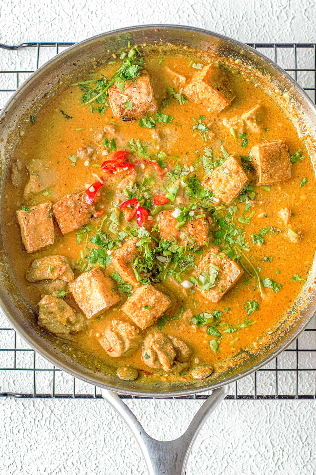 Tofu curry soup in a pan on a cooling rack.