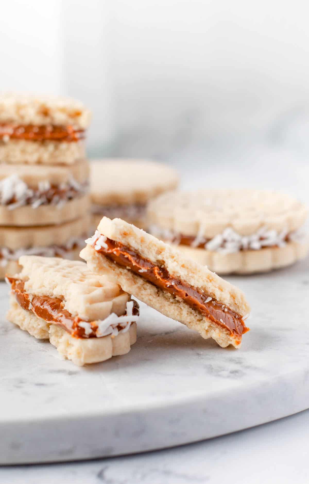 dulce de leche sandwich cookies on a marble trivet.