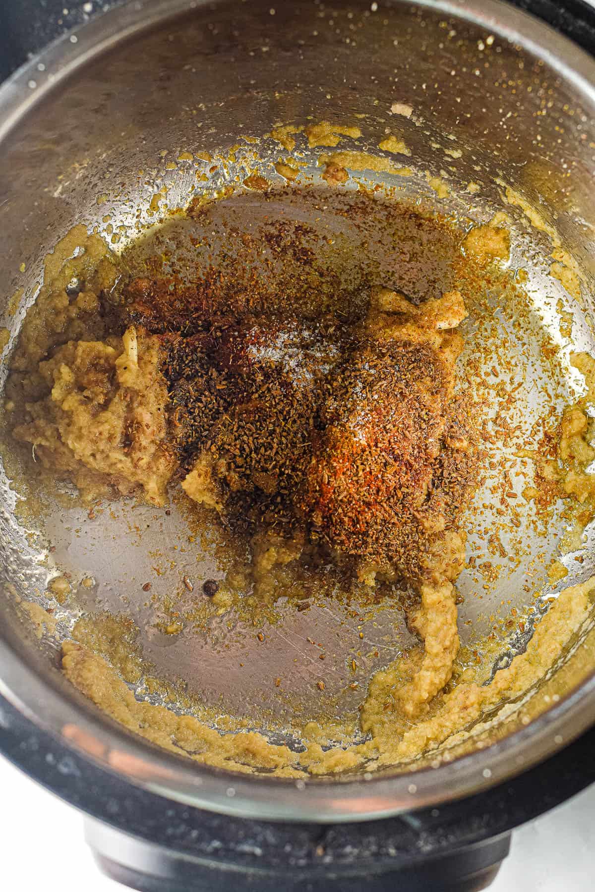 An Instant Pot filled with a flavorful mixture of spices in an Instant Pot Chicken Korma.