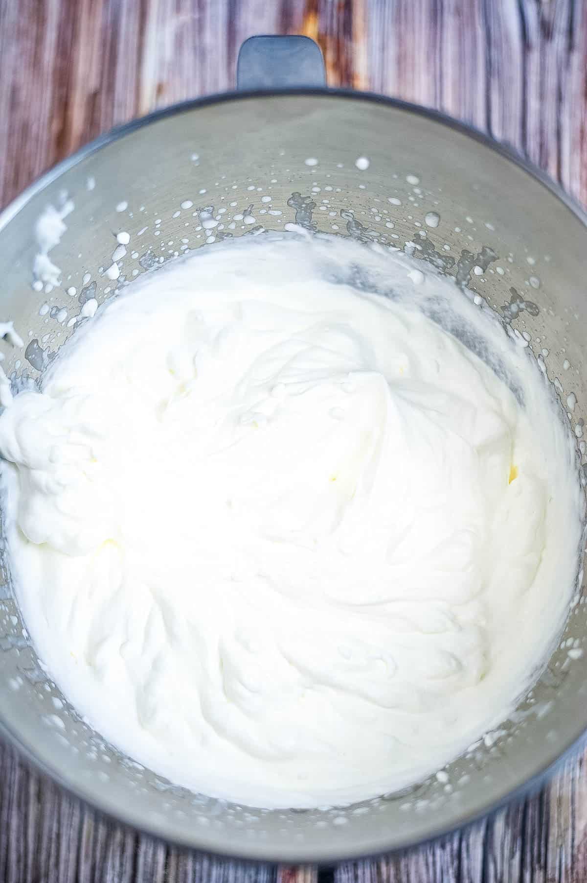 Whipped cream in a metal bowl.