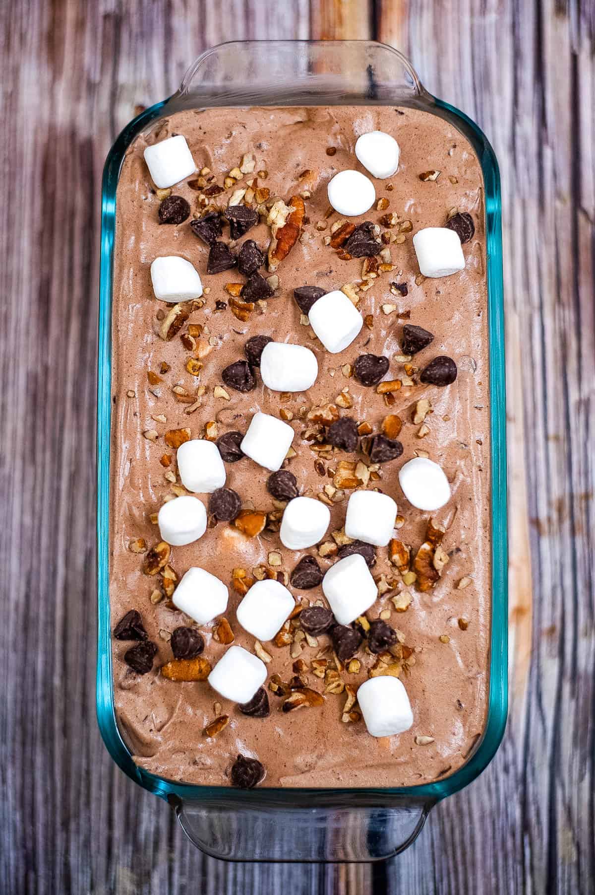 The finished ice cream in a loaf pan topped with pecans, chocolate chips, and marshmallows.