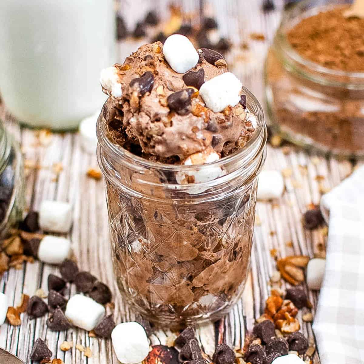 Close-up, low angle shot of a jar with rocky road ice cream in it.