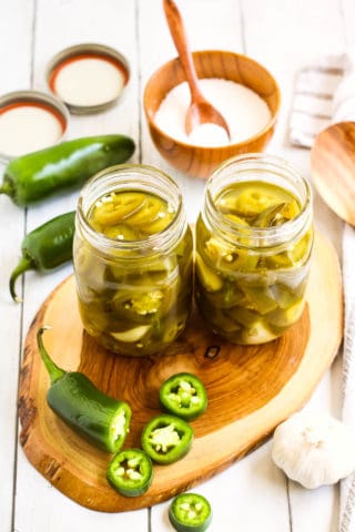 High angle shot of two pint size mason jars filled with pickled jalapenos.