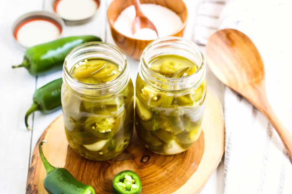 High angle shot of two pint size mason jars filled with pickled jalapenos.