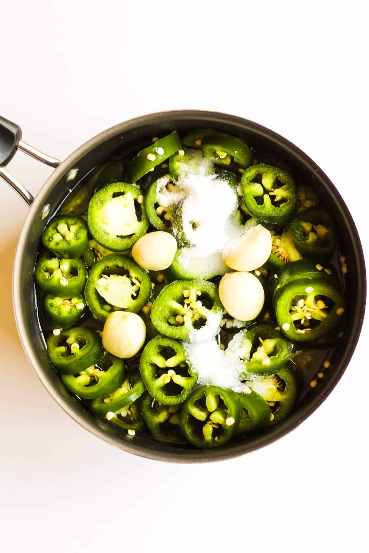 Pickled jalapenos and eggs in a skillet.