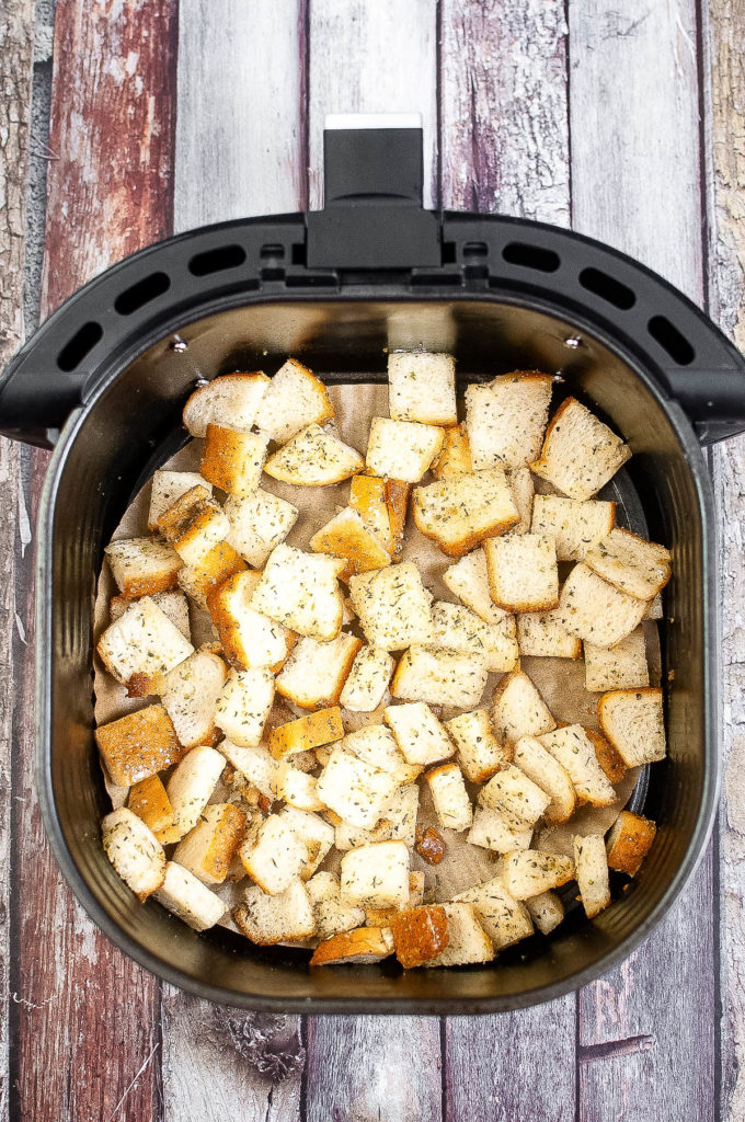Air fryer croutons on a wooden table.