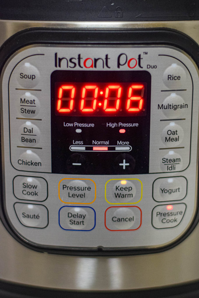 An instant pot with a timer for preparing shrimp biryani.