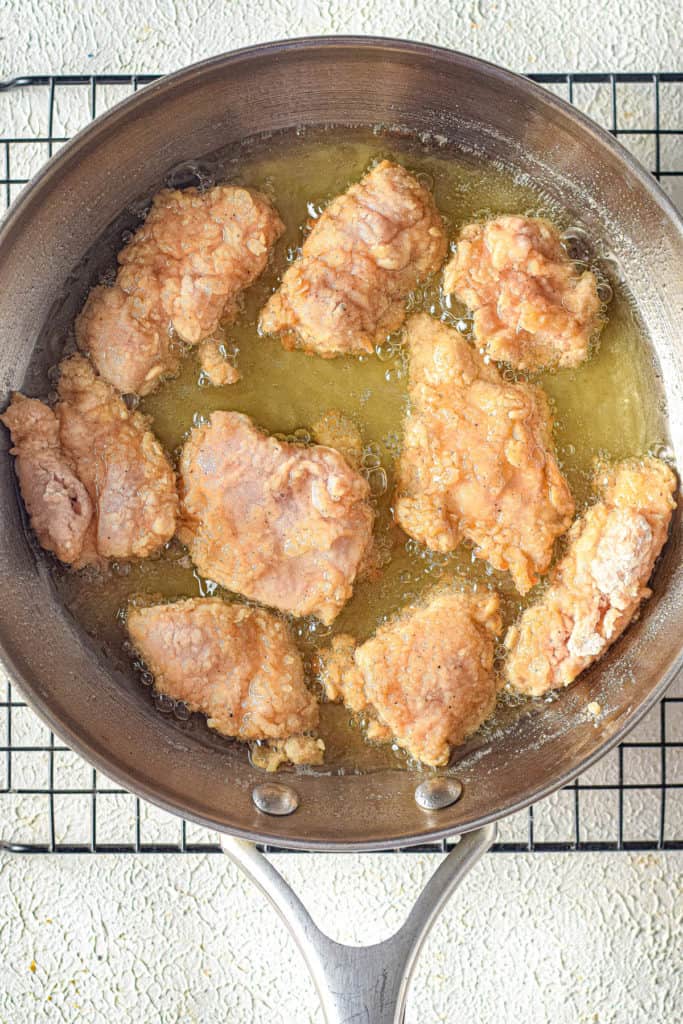 Frying the chicken in oil.