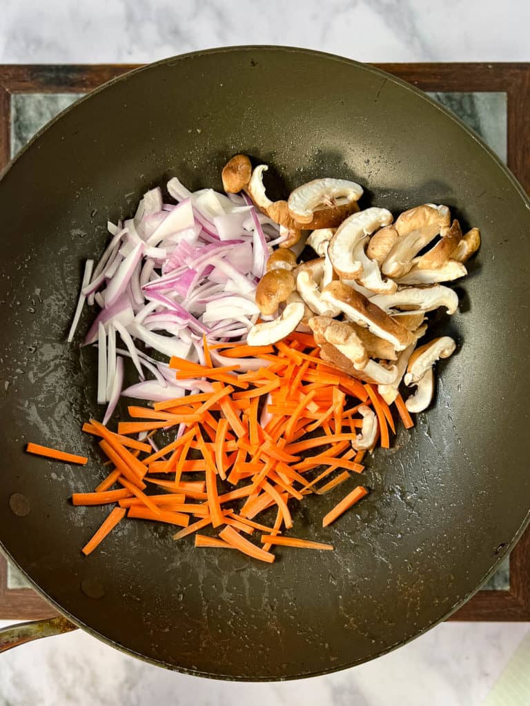 A shrimp yakisoba stir-fry with carrots, mushrooms and onions.