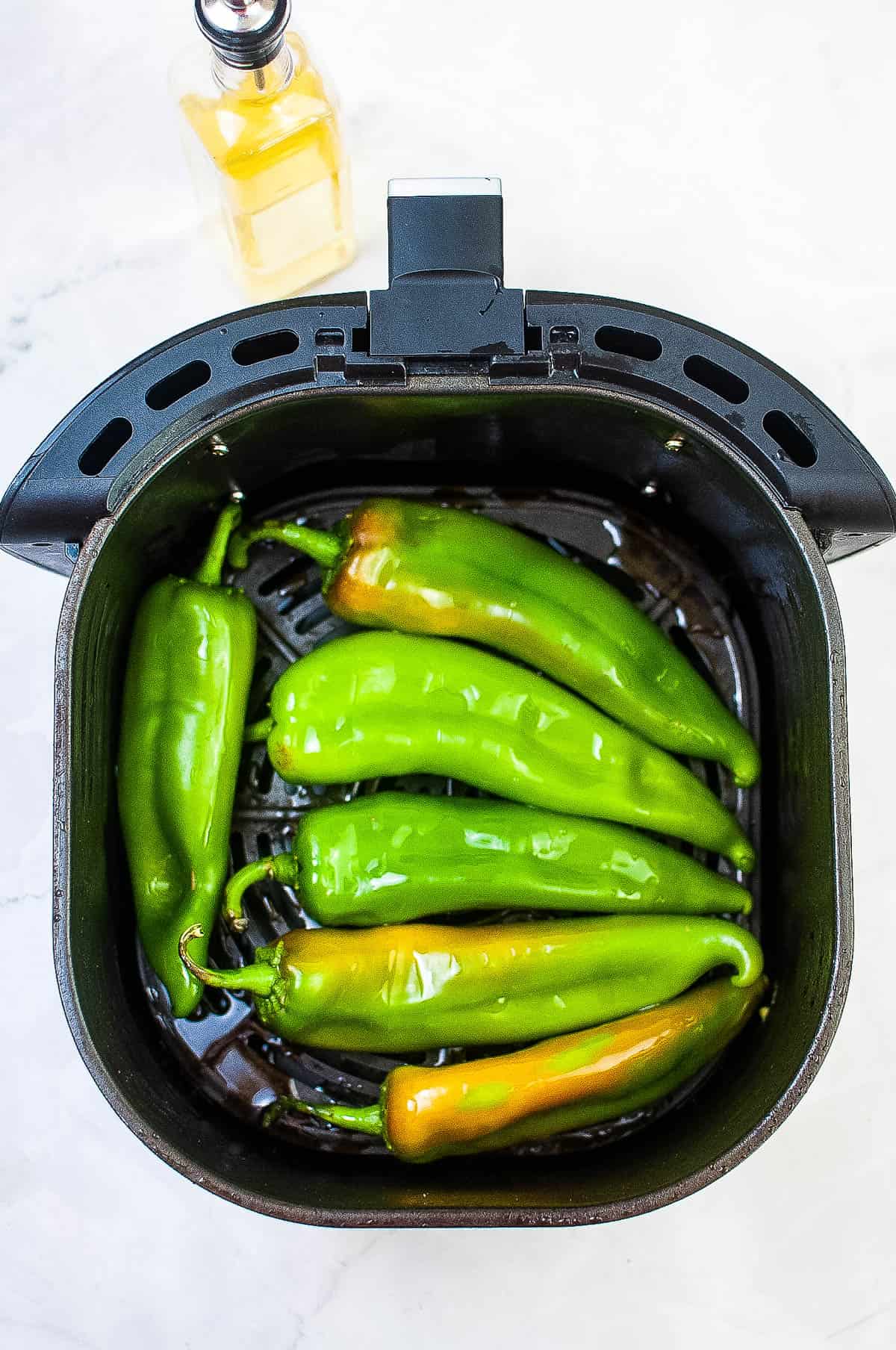An air fryer filled with hatch chiles roasted to perfection.
