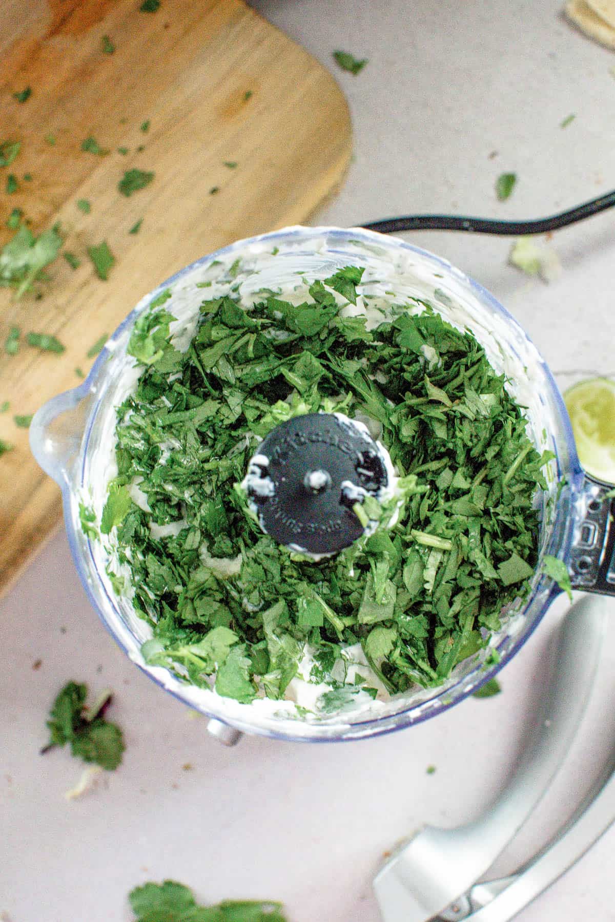 A food processor filled with cilantro and limes ready to enhance blackened mahi mahi tacos.