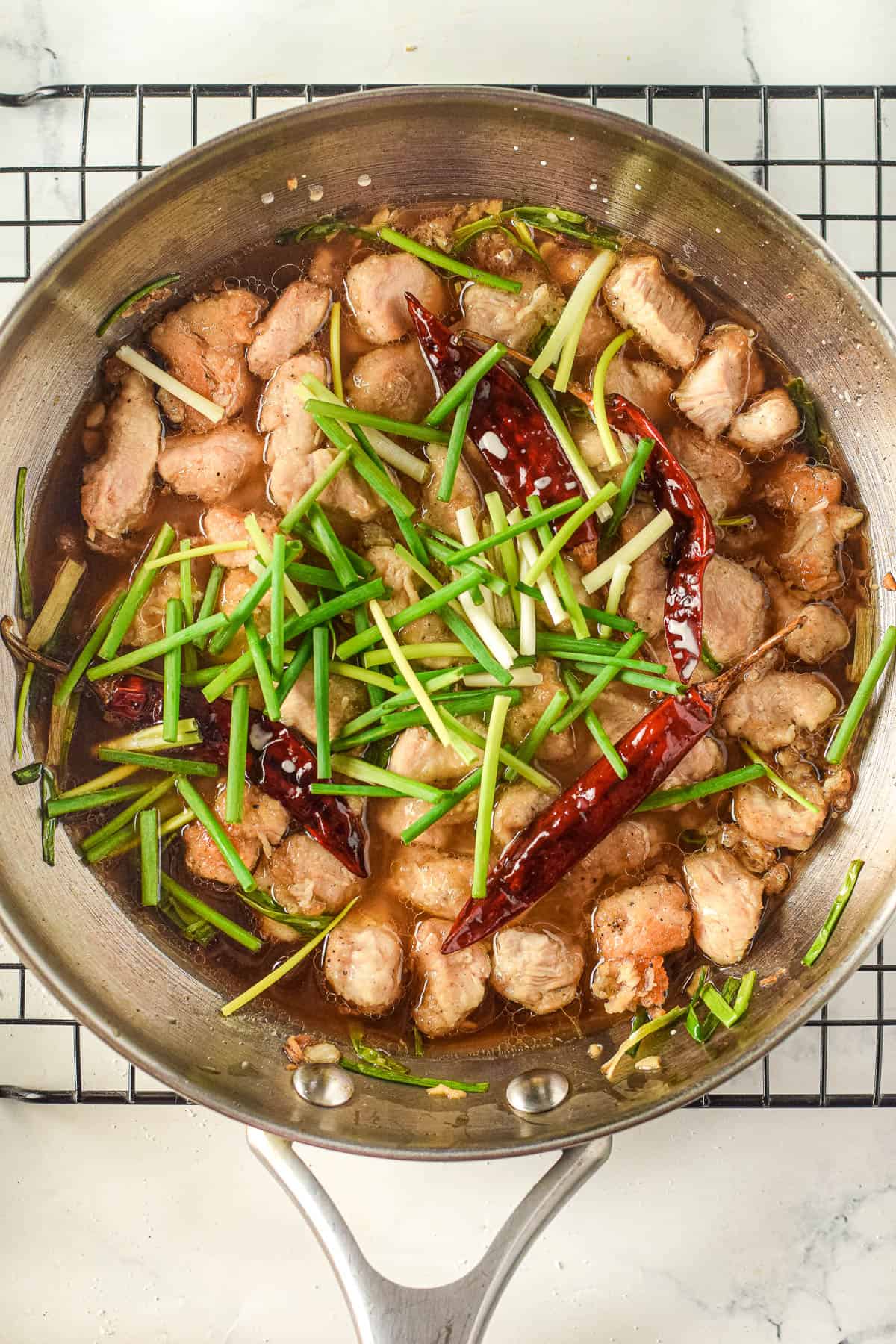 A Mongolian-style pan with chicken and green onions.