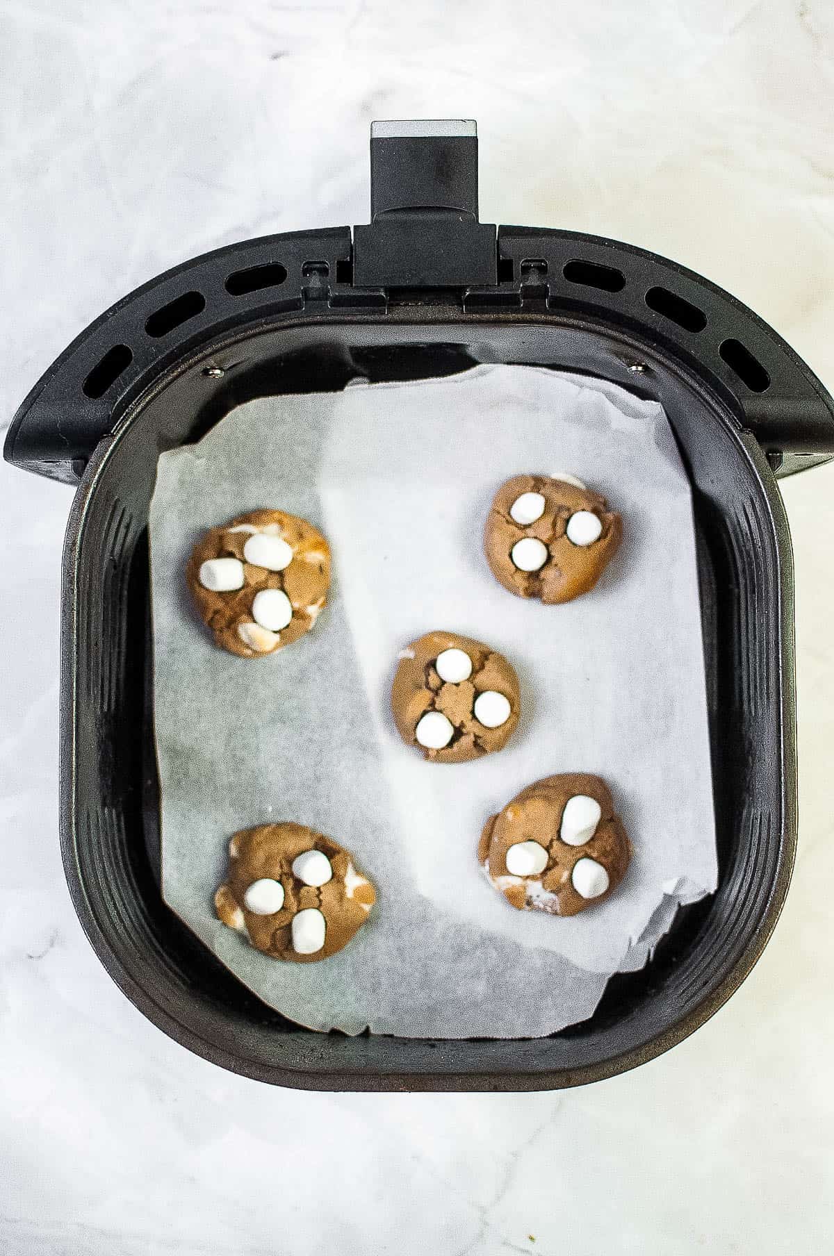 Air fryer filled with hot cocoa cookies.