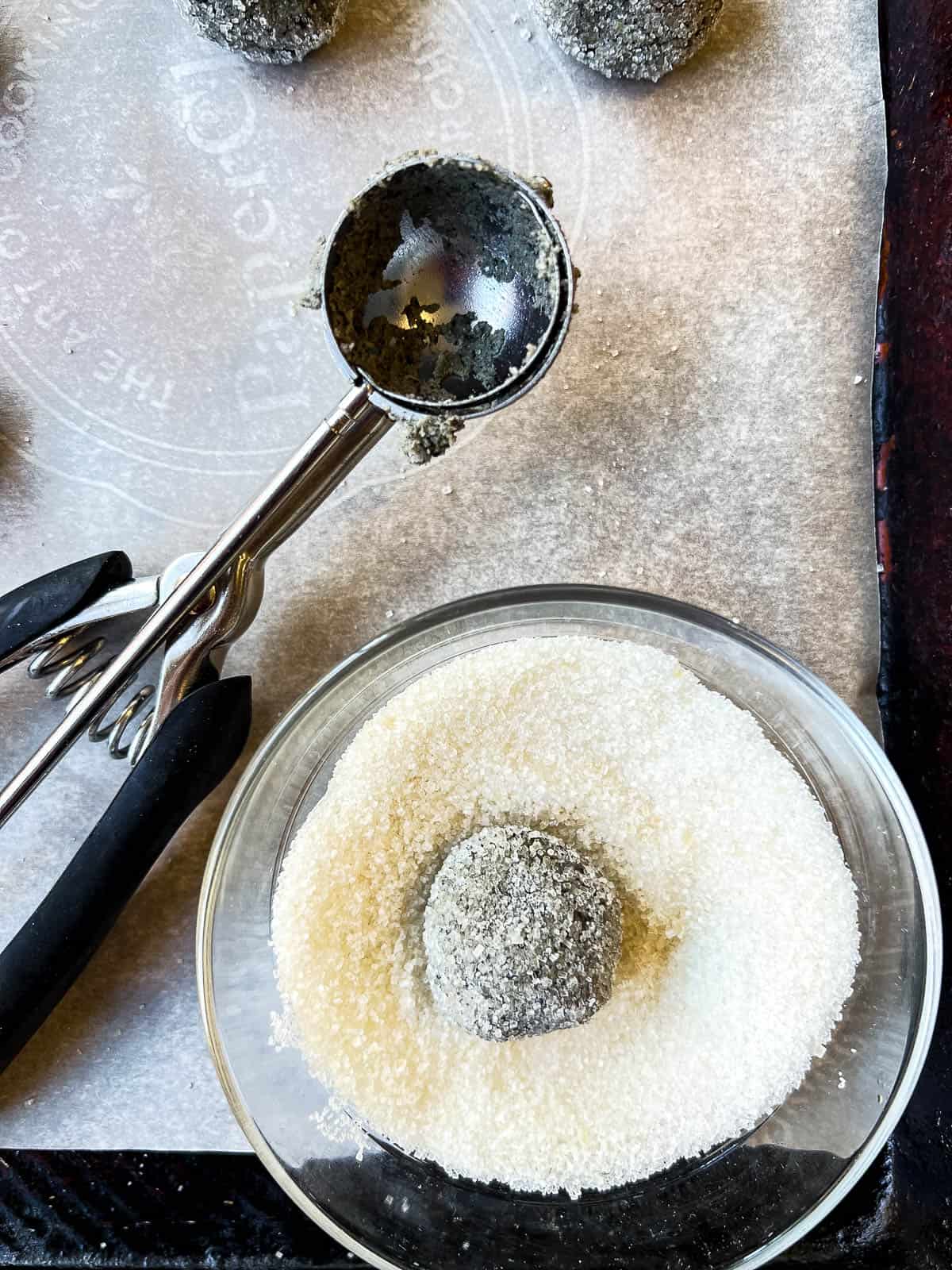 rolling a dough ball in sugar.