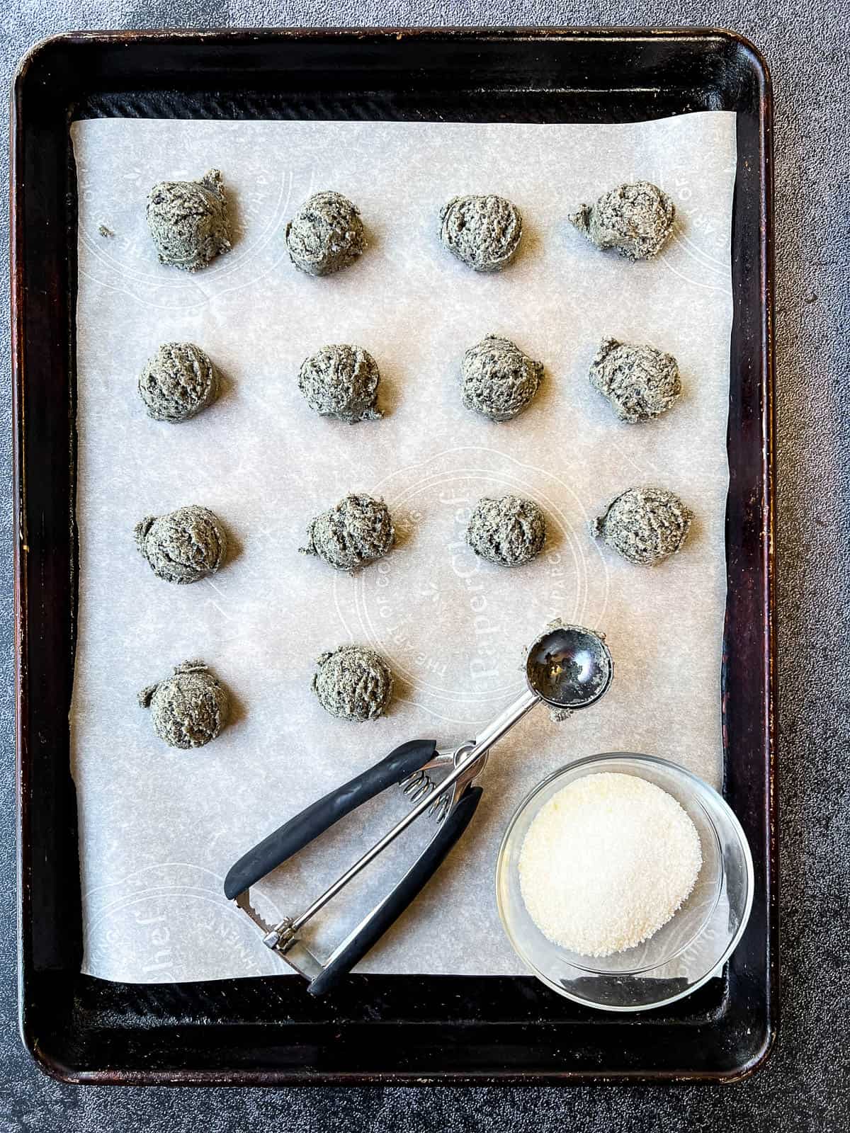 cookie dough balls on a baking sheet.