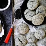 Black sesame cookies on a baking sheet with a spoon.