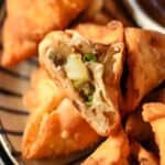 Fried samosas served with dipping sauce.