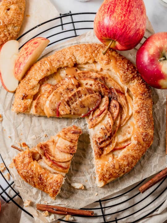 Overhead shot of an apple galette with apples on the side.