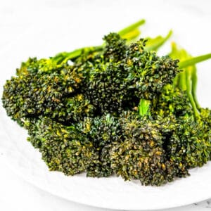 Low angle shot of a plate of air fried broccolini.